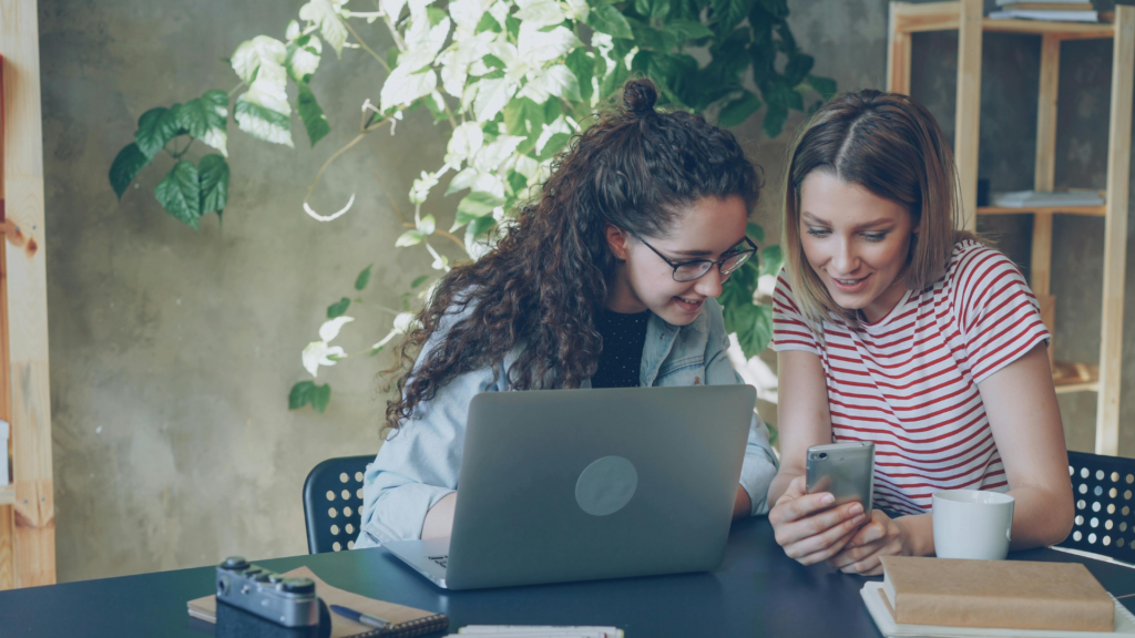 Two girls at desk looking at photos